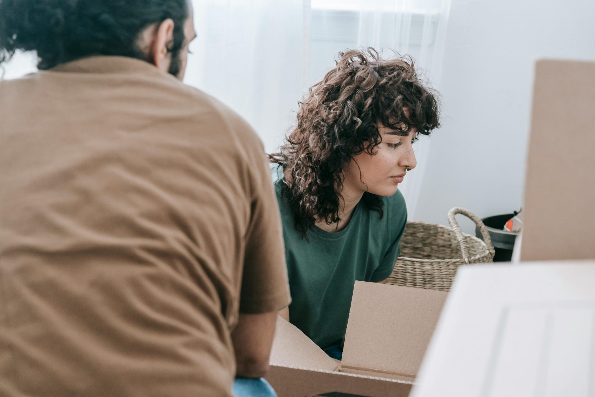 A couple taking a break while packing boxes during their move to a new home.